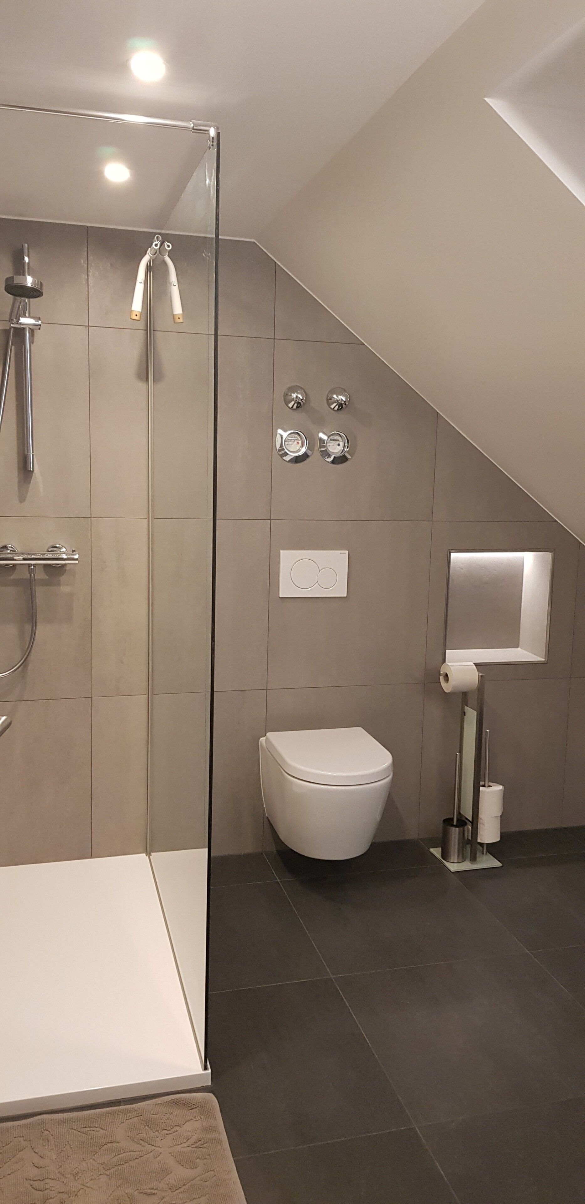 Ein modernes Badezimmer mit Duschkabine aus Glas, Toilette und Bidet.