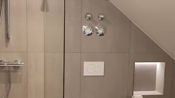 Ein modernes Badezimmer mit Duschkabine aus Glas, Toilette und Bidet.