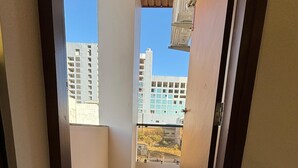 Un couloir au sol en marbre mène à un balcon d’où l’on peut admirer la vue sur les gratte-ciel.