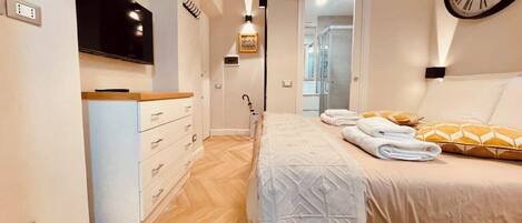 Ein Schlafzimmer mit einem Bett, einem Nachttisch und einer an der Wand befestigten Uhr.