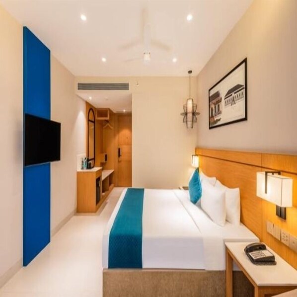 A hotel room with a bed, bedside table, lamp, and a framed picture on the wall. - Effotel By Sayaji Panaji, Goa (Panaji)