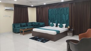 Une chambre d’hôtel moderne avec un grand lit, un canapé, une table basse et un fauteuil.