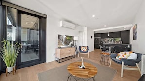 A modern apartment with a living area, kitchen, and dining space. - Bright Unit with Secure Parking and Garden Access (Reid)