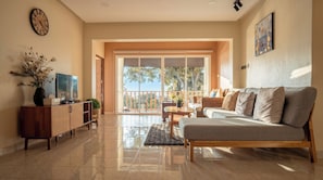 A living room with a sofa, TV, and a decorative vase. - Jaokhun Hilltop Patong Phuket (Patong)