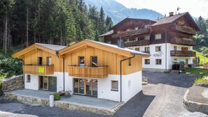 Een houten chalet met balkon en uitzicht op de bergen.