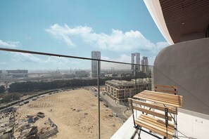 Ein Balkon mit Blick auf eine Baustelle und Gebäude in der Ferne.