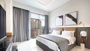 Een moderne hotelkamer met een groot bed, een bureau, een televisie en uitzicht op de stad.