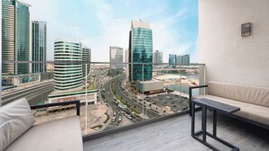 Een balkon met uitzicht op de stad, een bank en een tafel.