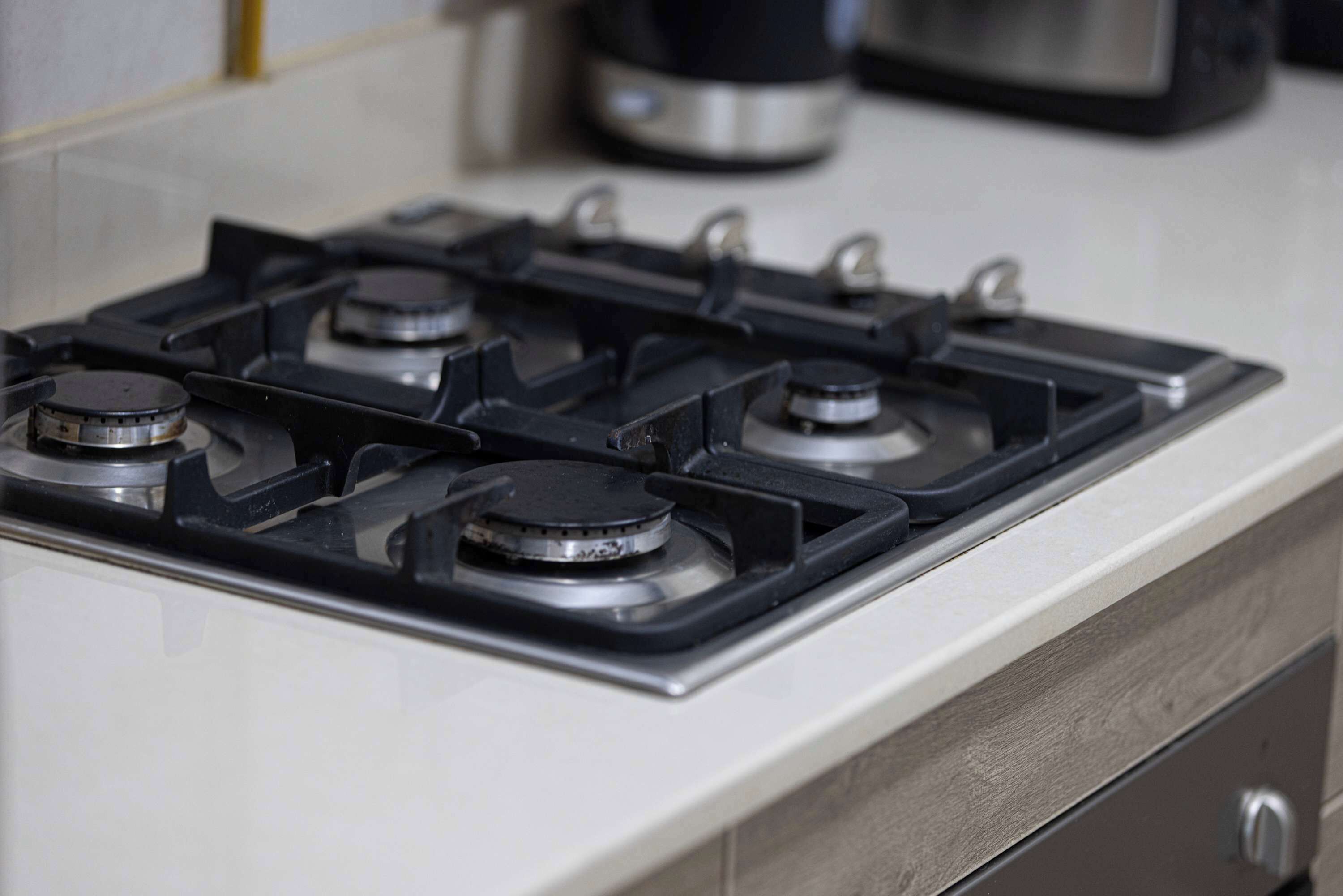 A kitchen with a gas stove and a microwave.