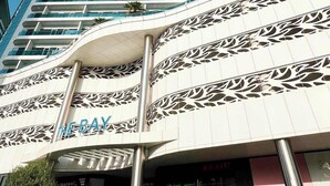 Un edificio moderno con fachada curva y un llamativo letrero 'The Bay'.