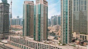 A high-rise building with multiple floors, large windows, and a prominent "EMAAR" sign. - Sophisticated 2-Bedroom Hideaway in MEG 318 (Business Bay)