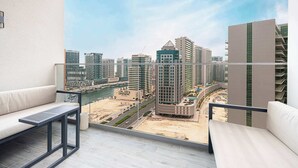 A balcony with a view of a cityscape, including high-rise buildings and a beach. - Sophisticated 2-Bedroom Hideaway in MEG 318 (Business Bay)