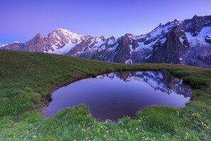 Un paysage de montagne avec un étang dans lequel se reflètent les sommets.