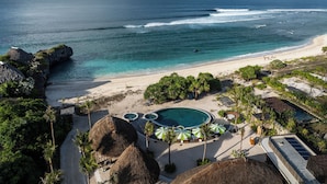 Un resort con piscina, playa y vista al océano.