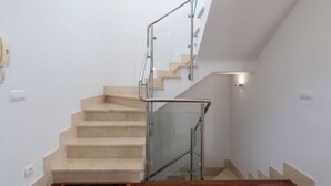 En modern trappa med glasräcken och beige trappsteg.