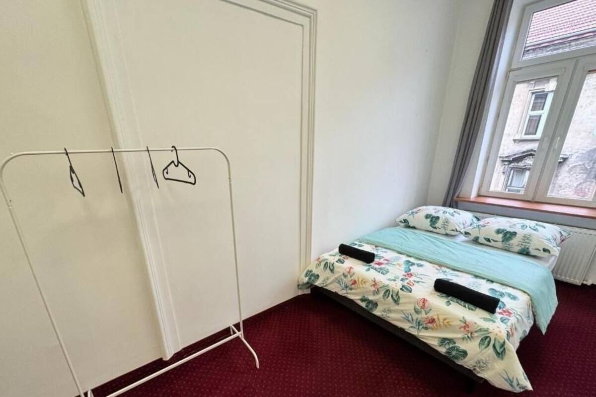A bedroom with a bed, a radiator, and a window.
