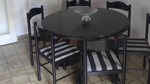 A dining area with a round table, four chairs, a chandelier, a radiator, and a white shelf with a toy. - 140 sqm, 5 rooms, up to 10 people (Ludwigshafen am Rhein)