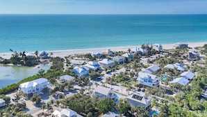 An aerial view of a coastal residential area with houses, a beach, and a clear blue sky. - The perfect Beach Cottage getaway! (Placida)