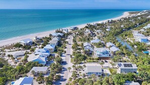 An aerial view of a coastal residential area with houses, a beach, and a clear blue sky. - The perfect Beach Cottage getaway! (Placida)