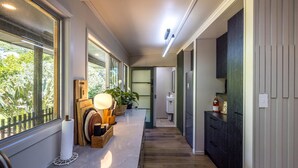 Eine moderne Küche mit einer langen Arbeitsplatte, Holzschränken und Blick ins Freie.