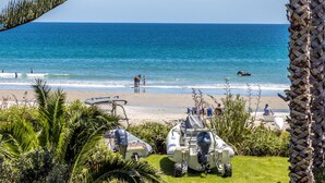 Ein Strand mit Booten, Menschen und freiem Blick auf den Ozean.