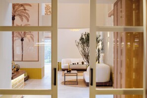 A modern living room with a white sofa, a coffee table, and decorative plants. - Gran Hotel Margalida Mallorca by Annua Signature - New Opening (Banyalbufar)