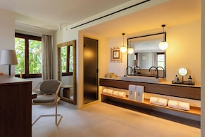 Un bagno moderno con uno specchio grande, portasci e una sedia.
