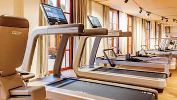 A gym with multiple treadmills, each equipped with a digital screen.