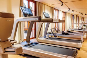 A gym with multiple treadmills, each equipped with a digital screen. - Gran Hotel Margalida Mallorca by Annua Signature - New Opening (Banyalbufar)