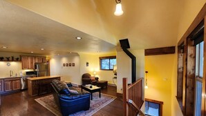 A spacious living area with a sofa, coffee table, and a kitchen in the background. - Tranquil 1-bedroom apartment in Donnelly perfect for a getaway (Donnelly)