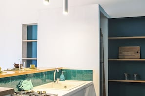 A modern kitchen with a white countertop, a blue faucet, and teal backsplash tiles. - Villa Bruca is a two-family house composed of two separate units.The unit offered, Villa Bruca 1, includes a double bedroom with the possibility of adding two single beds, a spacious bathroom with a modern walk-in shower, and a kitchen-living area equipp (Caronia)