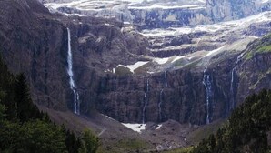 Un paysage montagneux parsemé de nombreuses cascades et de zones enneigées.