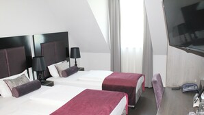 Ein Hotelzimmer mit zwei Betten, einem Schreibtisch, einem Fernseher und einem Telefon.