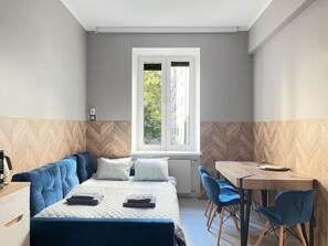Una habitación moderna con cama, escritorio y ventana.