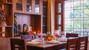 Comedor con una mesa dispuesta para cuatro, armarios de madera y una estatua.