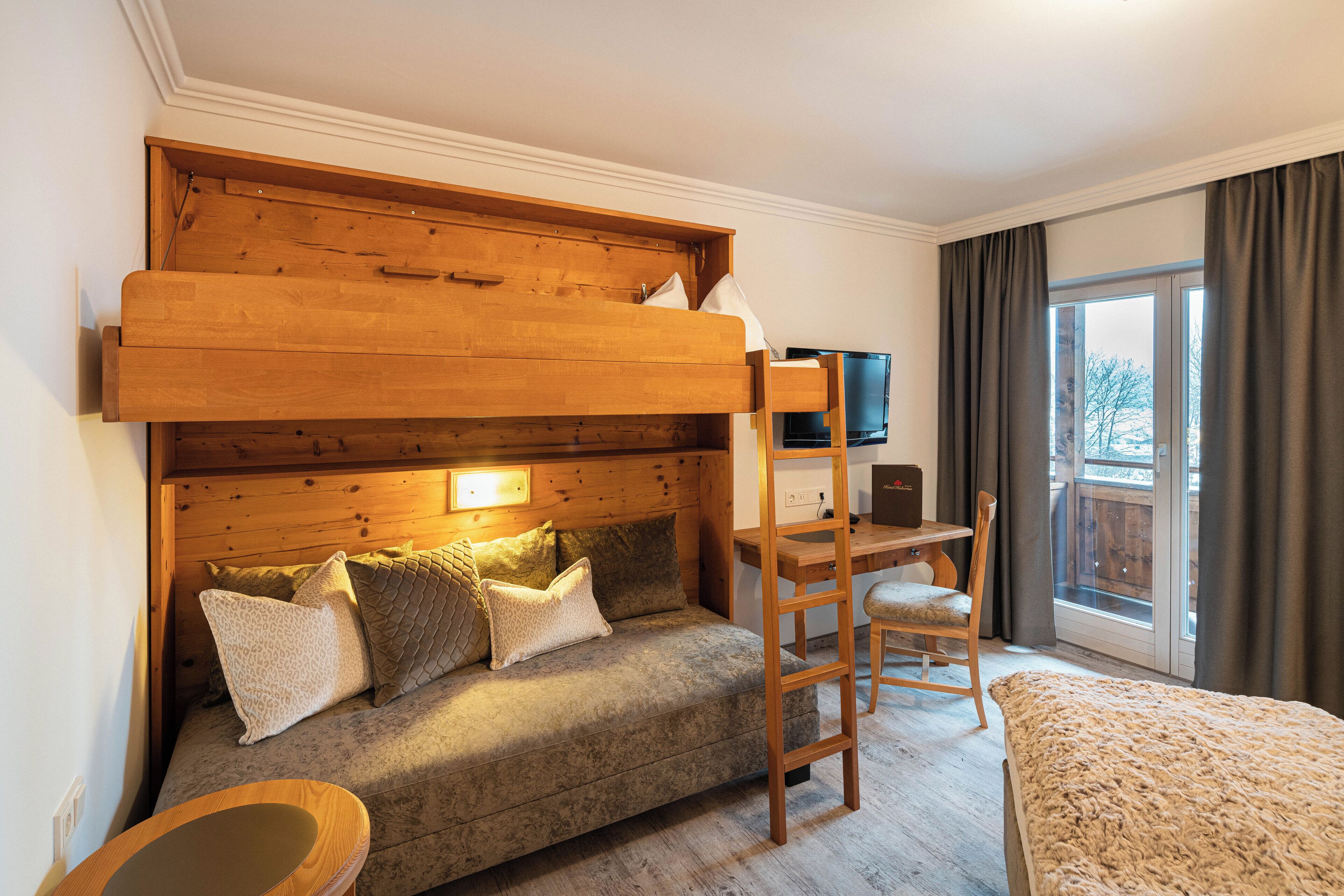 A cozy room with a bunk bed, a desk, and a chair.