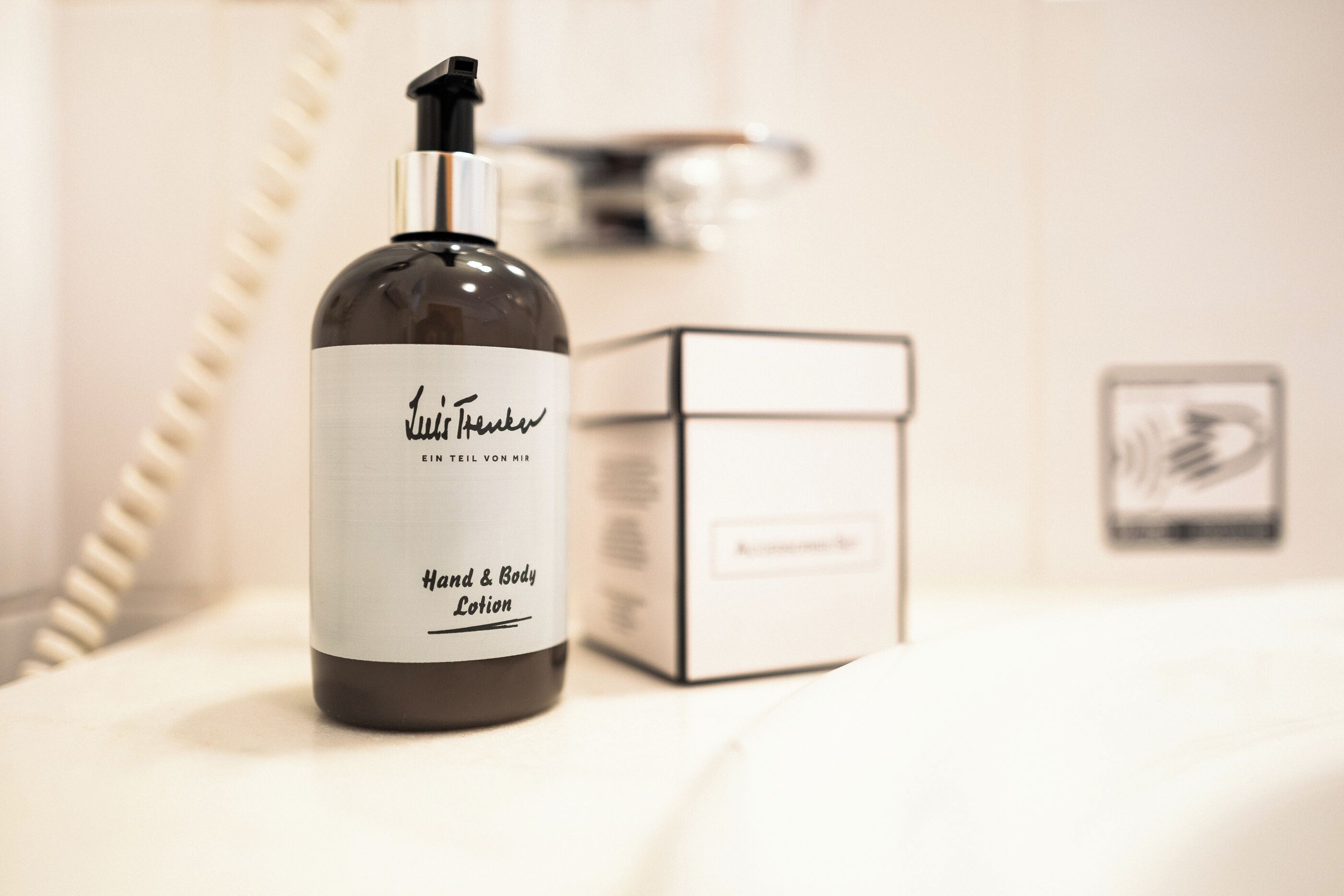 Eine Flasche und Verpackung von Hand- und Körperlotion auf weißem Untergrund.