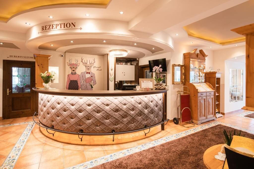 A reception area with a tufted counter, a sign reading "RECEPTION," and a wall with a deer illustration.