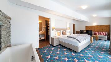 Une chambre d’hôtel moderne avec un grand lit, une télévision, une tête de lit en bois et un mur décoratif en pierre.