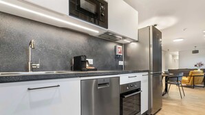 Eine moderne Küche mit Edelstahlgeräten, einem eingebauten Backofen und einer Mikrowelle.