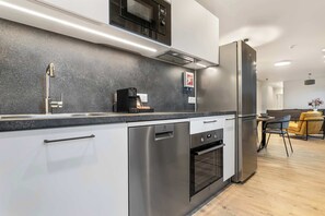 Eine moderne Küche mit Edelstahlgeräten, einem eingebauten Backofen und einer Mikrowelle.