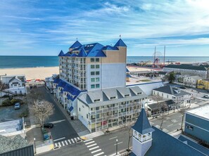 Un hôtel en bord de mer, avec plusieurs étages, une tour imposante et une vue sur la plage.