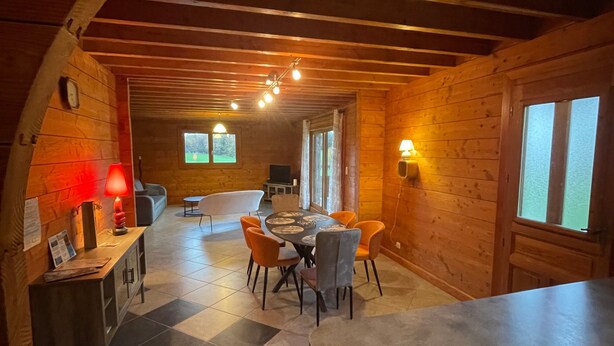 A wooden interior with a dining area, a kitchen, and a living space.