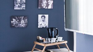 A modern room with a white desk, a black chair, a coffee table with a kettle, cups, and a tray. There are six black-and-white photographs on the wall. - Holiday Naples art room   (Naples)