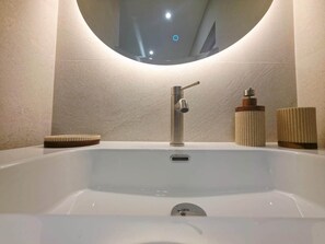 A modern bathroom with a large sink, a mirror, and a small bottle of soap. - Cosy Cocoon (Cagnes-sur-Mer)