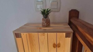 A wooden bedside table with a white lamp and a small plant. - Loù Cabanoù 35 m from the seafront (Marseille)