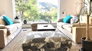A living room with two sofas, a coffee table, and a potted plant. - Spacious villa near beach with pool and Wi-Fi (Roses)