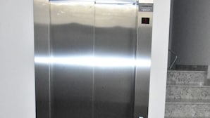 En metalelevator med et kontrolpanel på højre side.