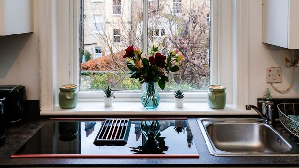 Una cocina con ventana, un lavamanos y una estufa.