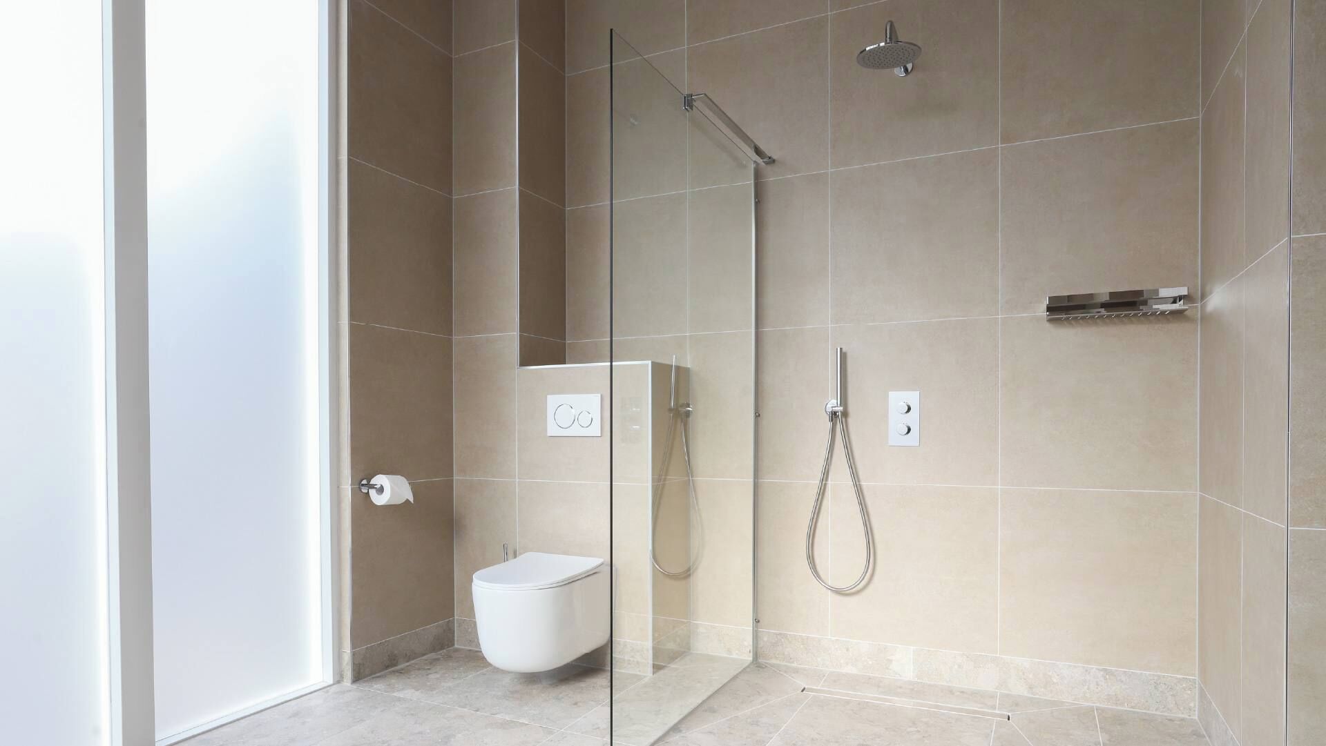 A modern bathroom with a glass-enclosed shower, a toilet, and a sink.
